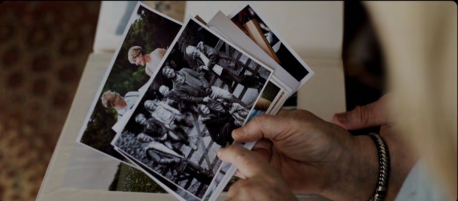 A hand holding a small stack of printed family photographs
